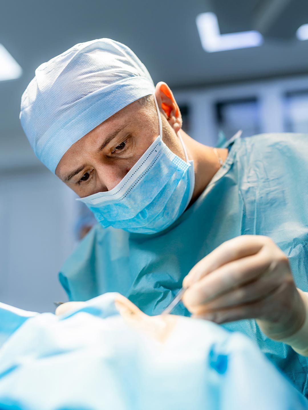 male veterinarian wearing scrubs performing surgery male veterinarian wearing scrubs performing surgery