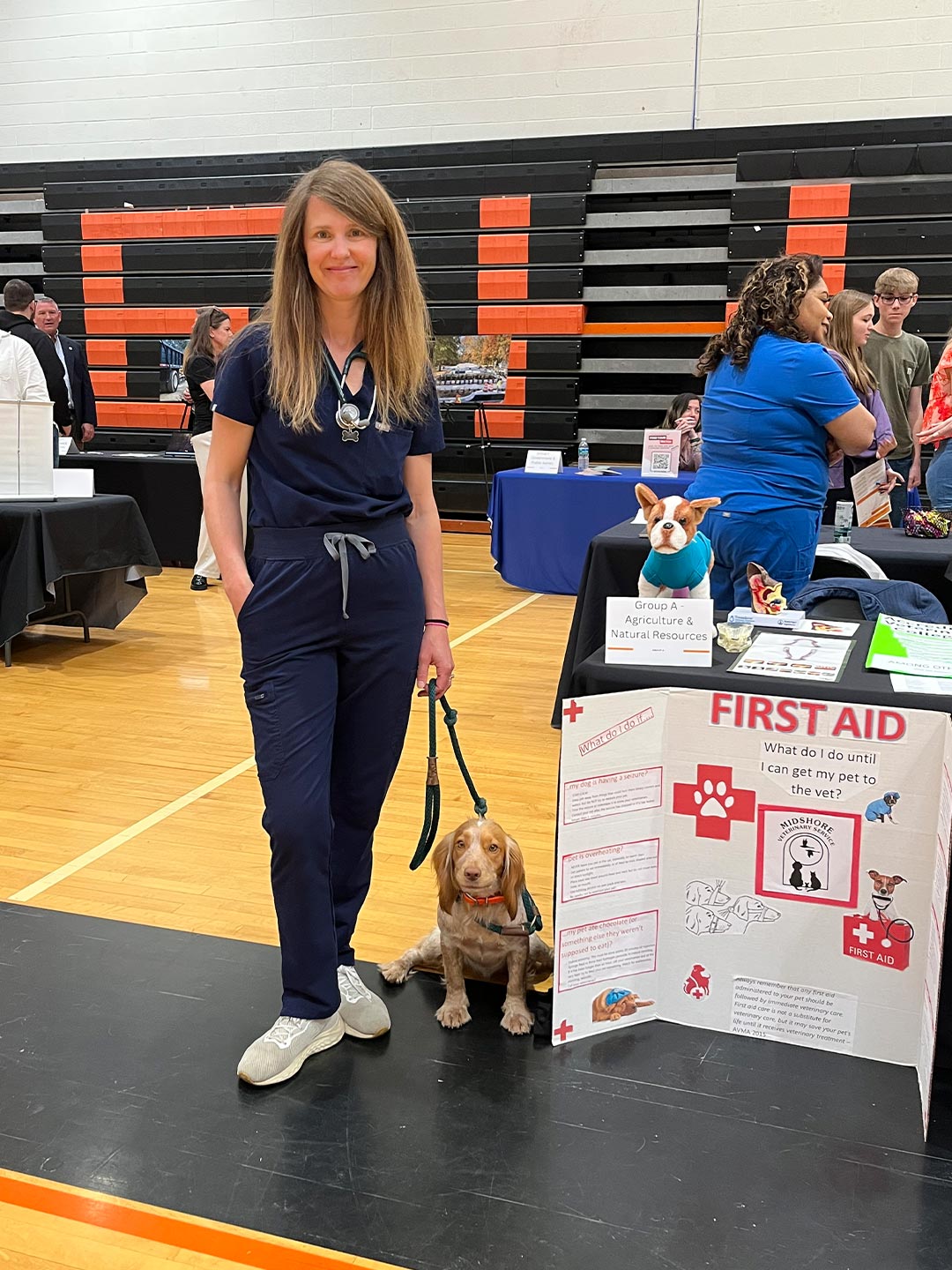 female veterinarian posing at event with small dog on leash female veterinarian posing at event with small dog on leash